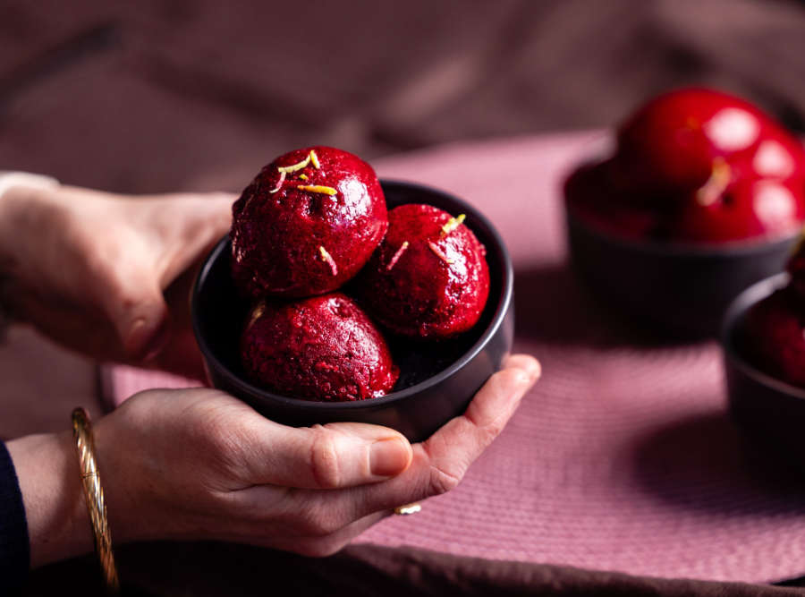 Hands holding a bowl of raspberry and lime sorbet.