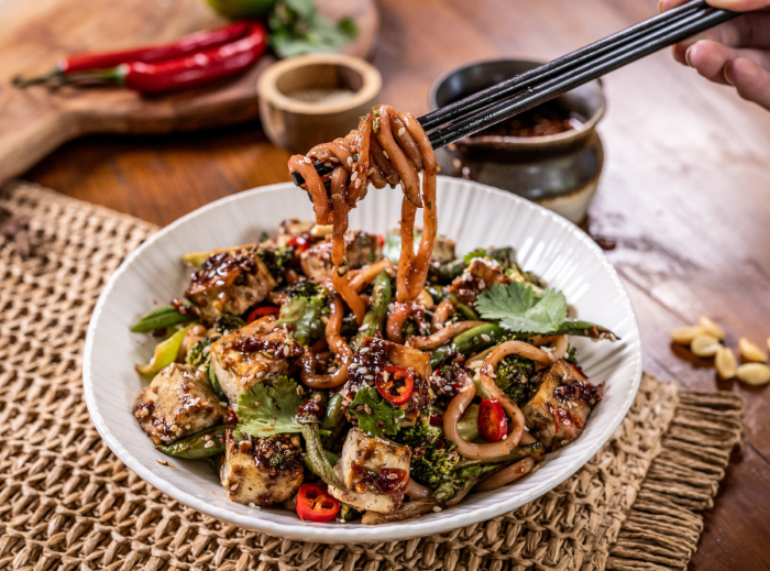 A bowl of peanut sesame udon noodles with tofu